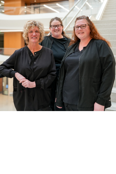 From left to right: Lisa Fisher, Jennifer Sickles and Shannon Dale surigcal skills center coordinators on stairs in the new Medical Education Research Building