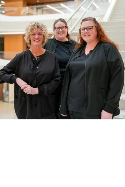 From left to right: Lisa Fisher, Jennifer Sickles and Shannon Dale surigcal skills center coordinators on stairs in the new Medical Education Research Building