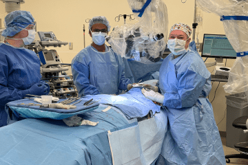 Mary Lester, MD, APD of Microsurgery and trainee Abbas Hassan, MD, PhD, working in OR for a microsurgery case.