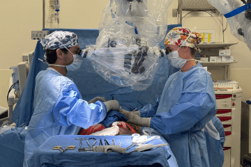 Rachel Danforth, MD, PD of Microsurgery and male trainee during a clinical microsurgery case.