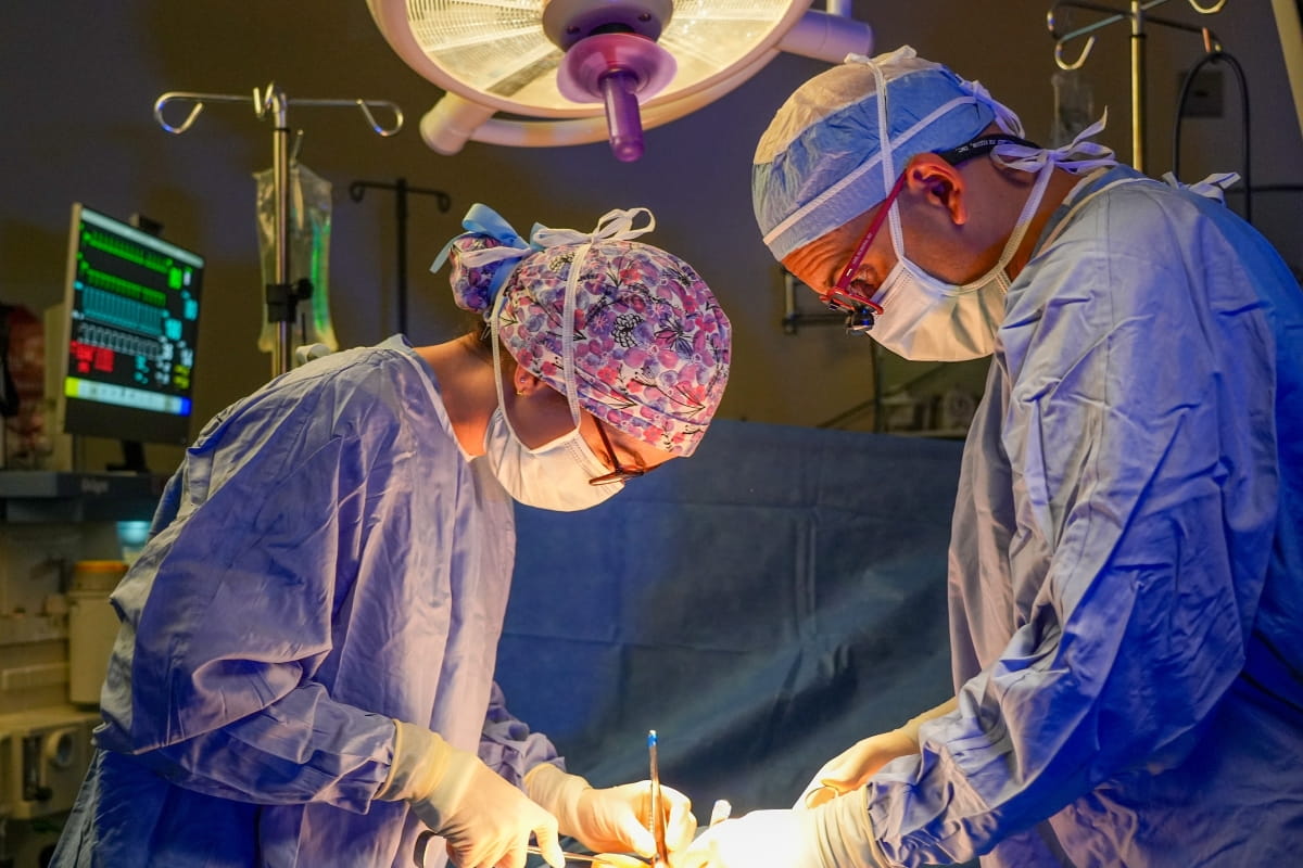 two surgeons focus on their work in the operating room