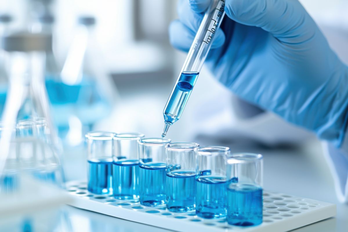 A gloved hand prepares a research sample in the lab