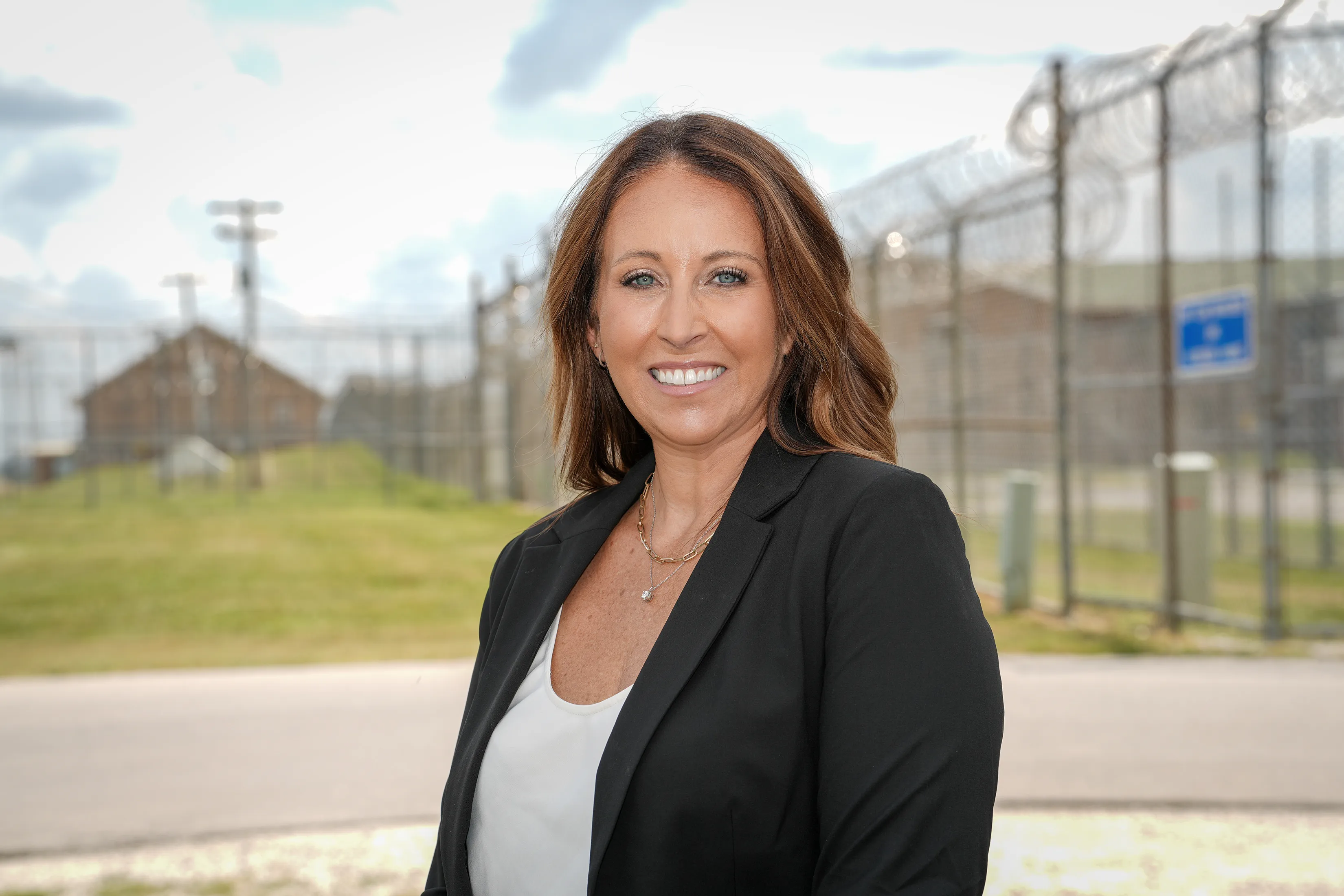 A woman poses in front of a prison
