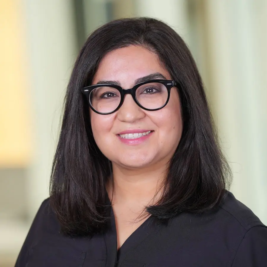 woman with dark hair and glasses