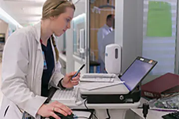 Student working on a laptop in a white coat