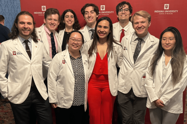 Group of 9 MSTP students in their white coats at the 2024 White Coat ceremony