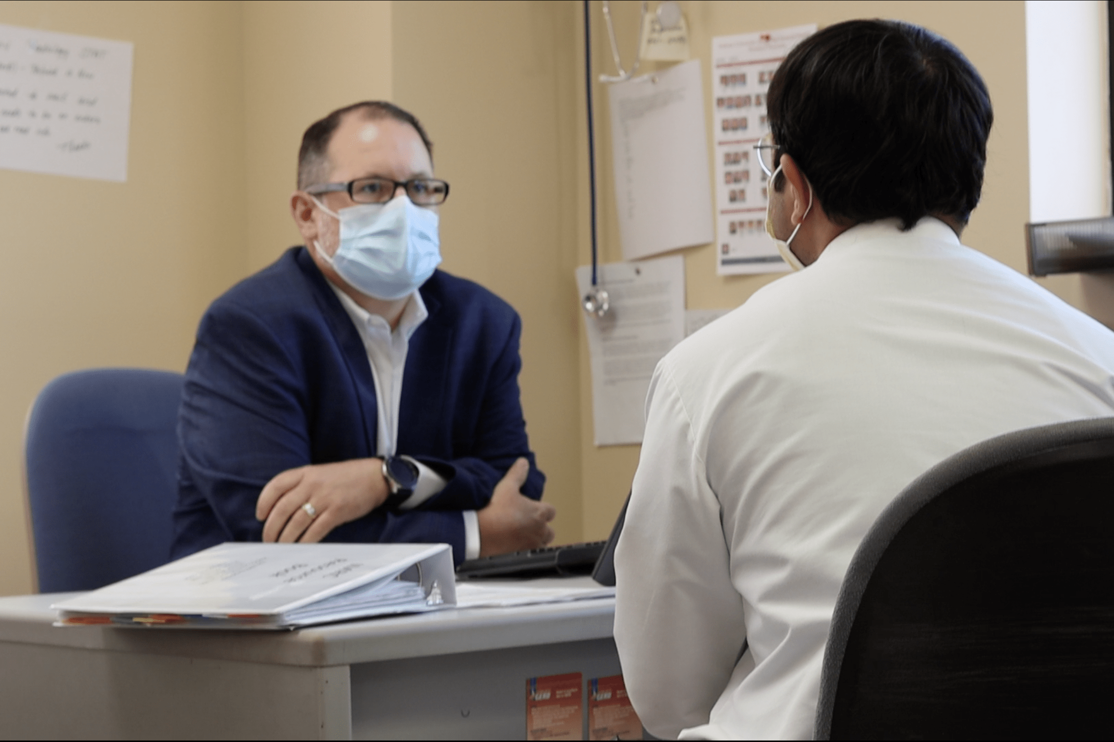 a resident and faculty member meet together in an office