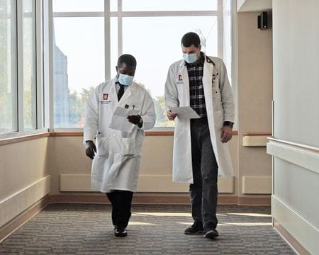 two residents walk down the hall together with a beautiful in the background