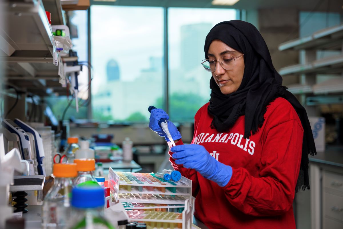 a grad students prepares a sample in the lab