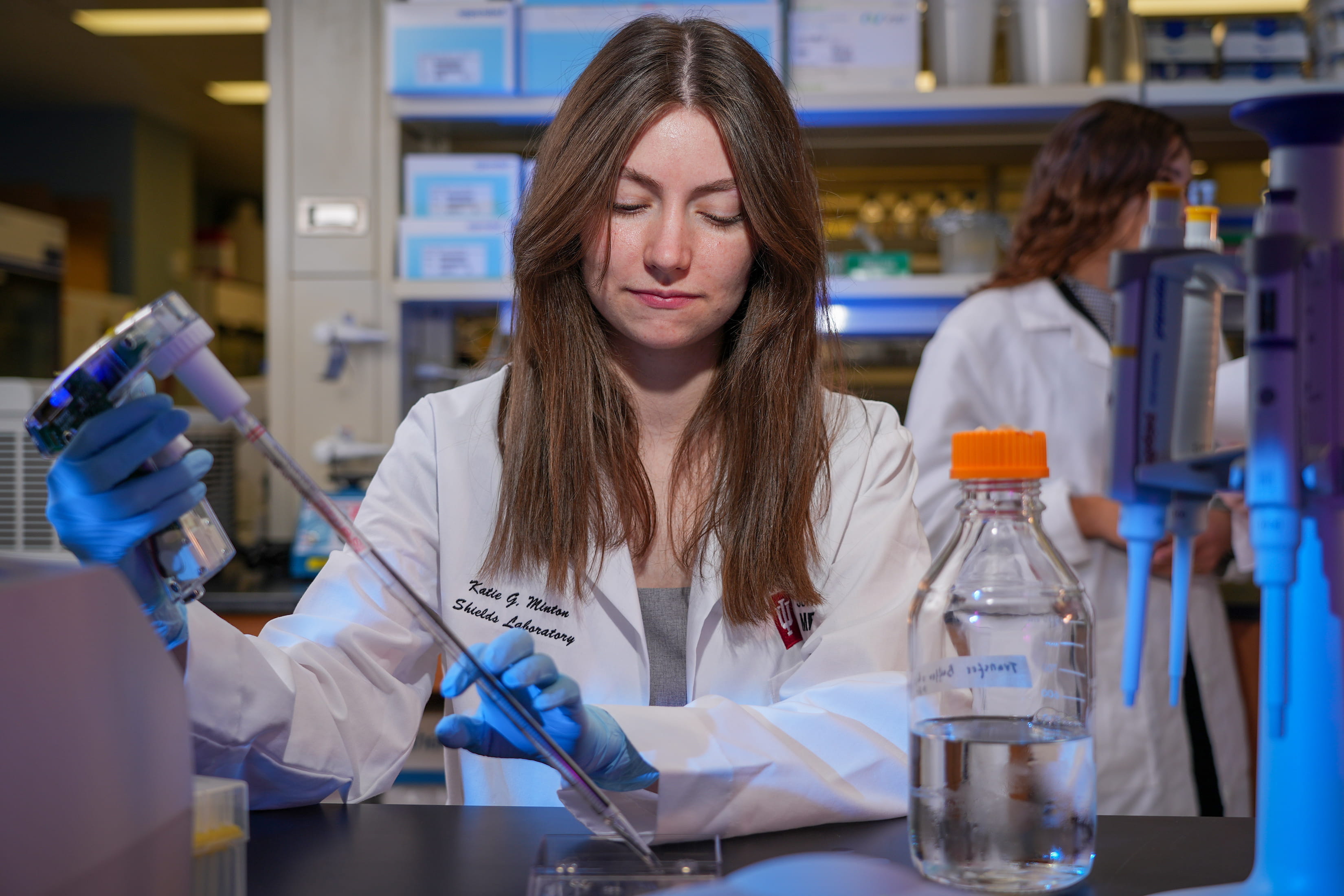 A female scientist pipettes in Dr. Shields' laboratory.
