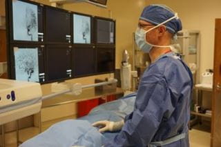 A male IR radiologists views veins.