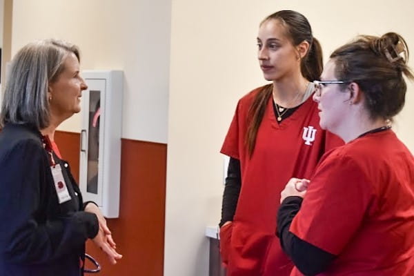 Two IU School of Medicine students talk with staff at a care-giving facility
