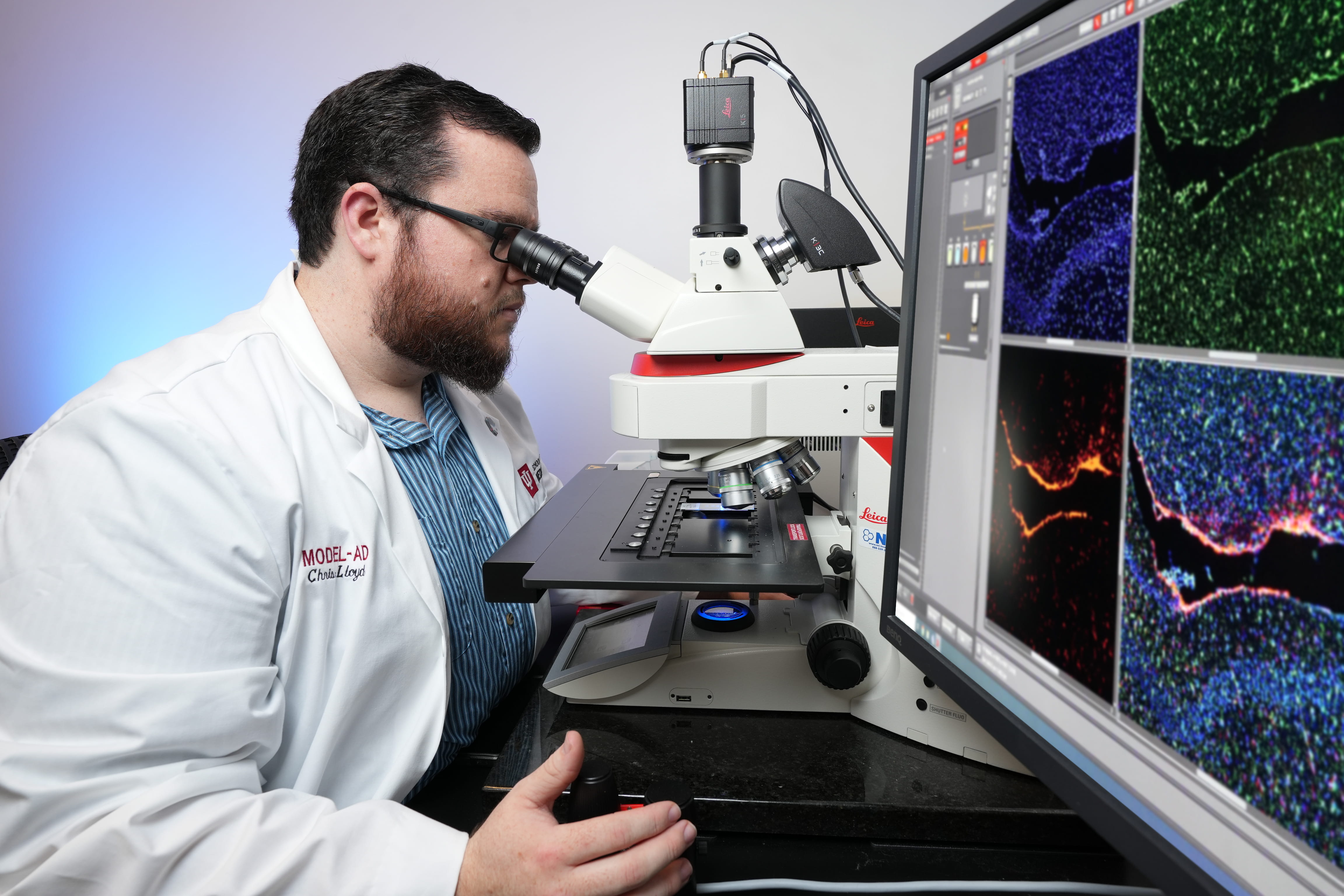 A researcher looks through a microscope