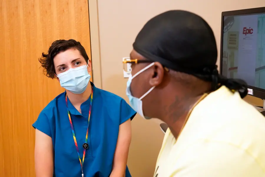 hannah locke speaks with a patient in clinic