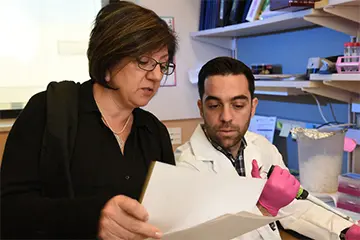 Two researchers in the lab review data together