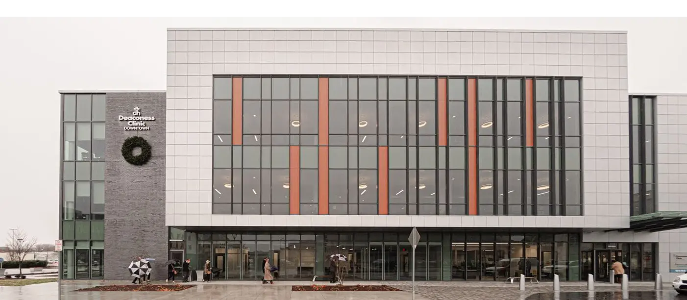 a building with stone and glass facade on a gray rainy day