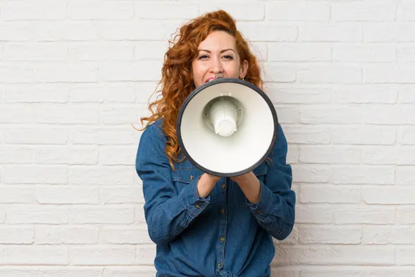 A woman is shown holding a megaphone, symbolizing her communicating about something important.