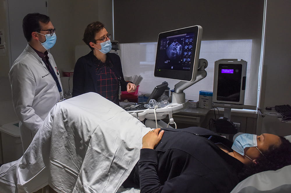 A team of physicians performs a gynecologic ultrasound on a patient