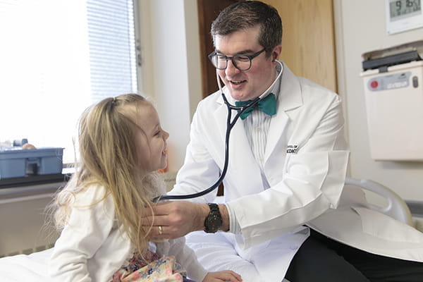 A pediatrician measures the heart rate of a young patient at Riley Children's Health.