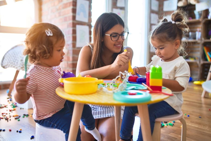 a day care provider plays with two small children