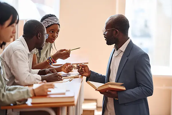 A professor speaks with students during a classroom exercise