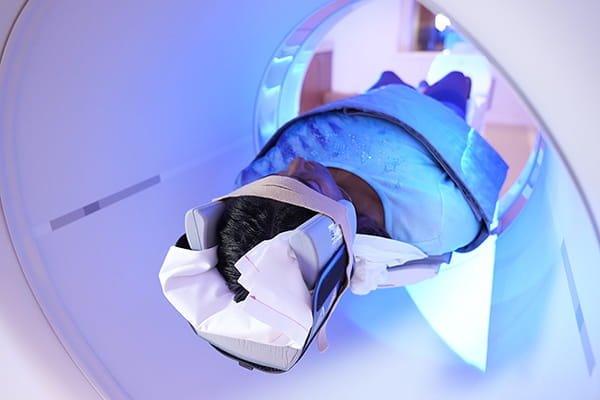 An image shows a woman moving through a CT scanner