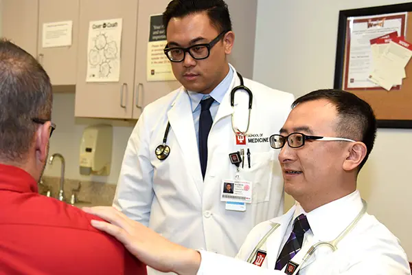 An attending physician and resident take care of a patient