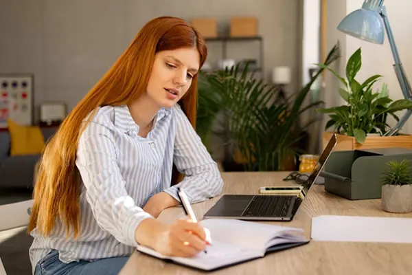A woman takes notes while conducting research