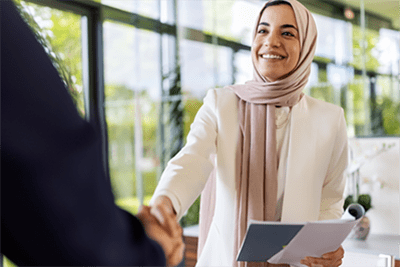 Two people shake hands at a job interview