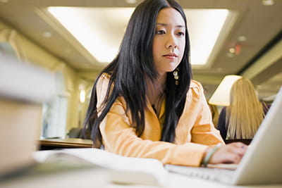 A woman searches for funding on her computer