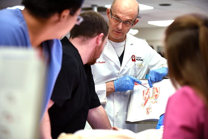 An instructor teaches medical students during a lab exercise.