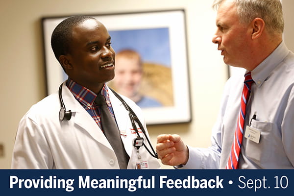 A photo of an experienced physician talking one-on-one with a younger physician is overlaid with text that reads, "Providing Meaningful Feedback, Sept. 10"