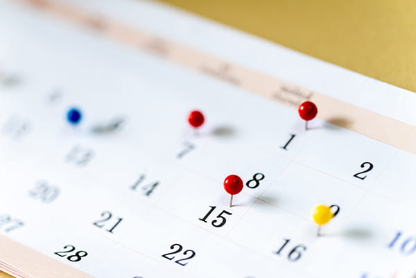 Undated calendar with colorful pushpins in various date squares