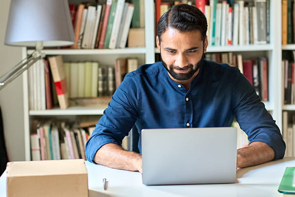 A young male professional works at a laptop