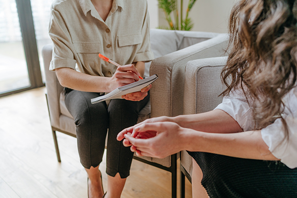Two women talk confidentially