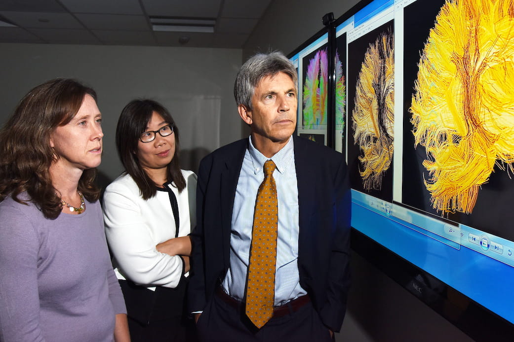 Brenna McDonald, Yu-Chien Wu and Thomas McAllister look at brain scans