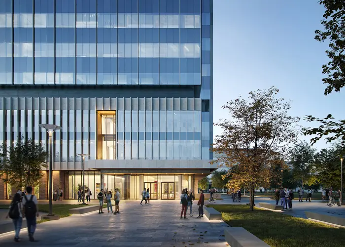 the back of the new building with people gathering outside at twilight