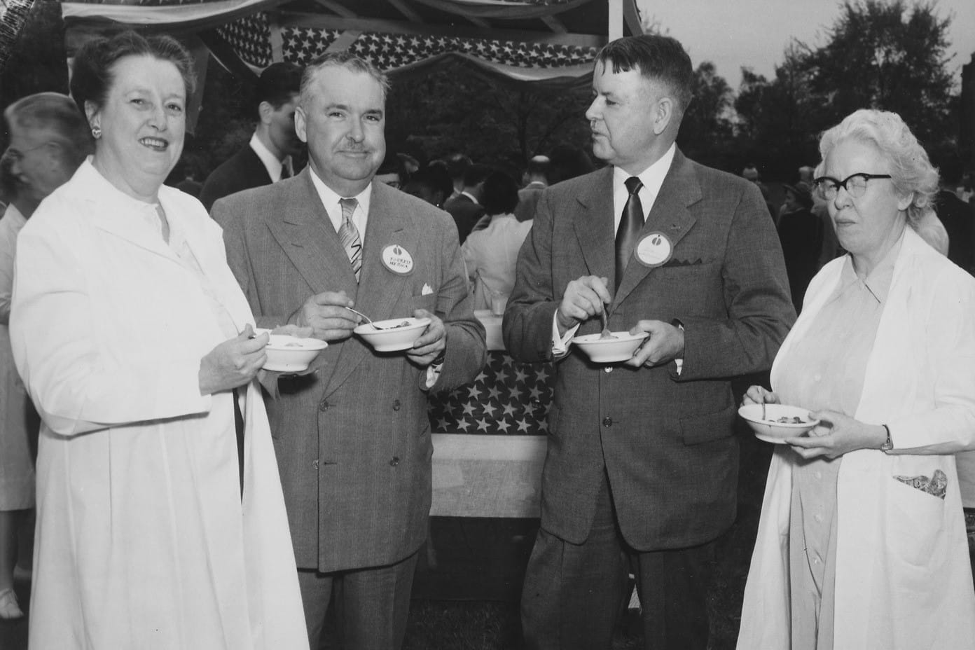black and white photo of four faculty members at a long-past luncheon