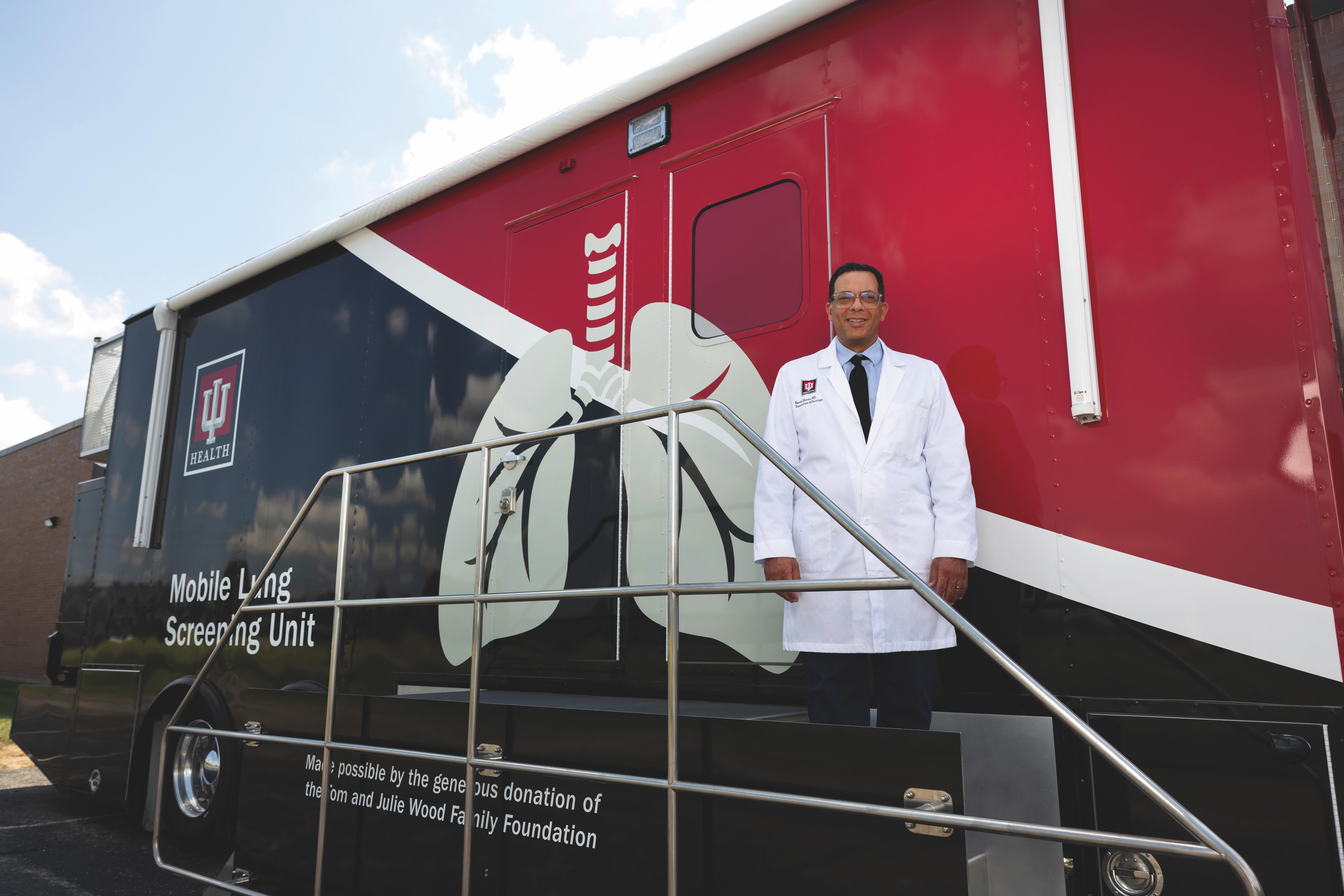 Cancer screening van with a person standing in front