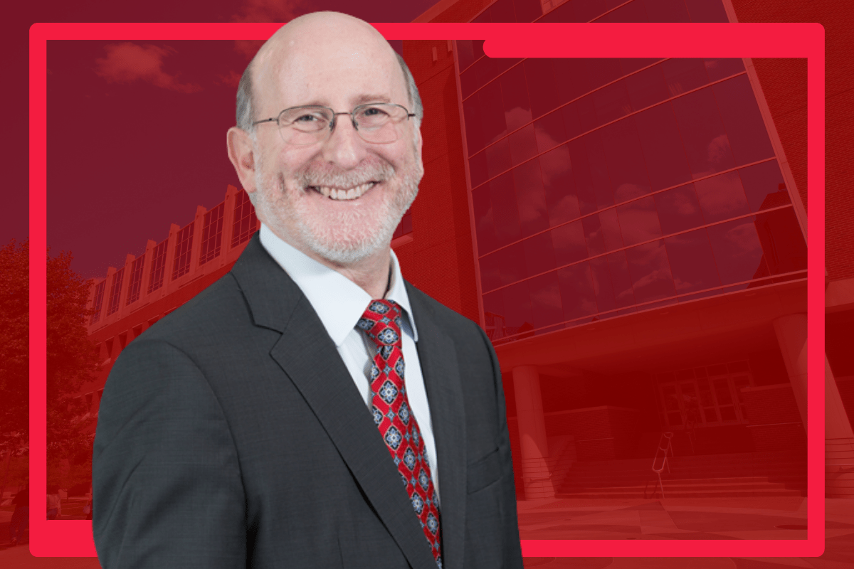 Greg Sachs, MD, is picture against a plain red background.