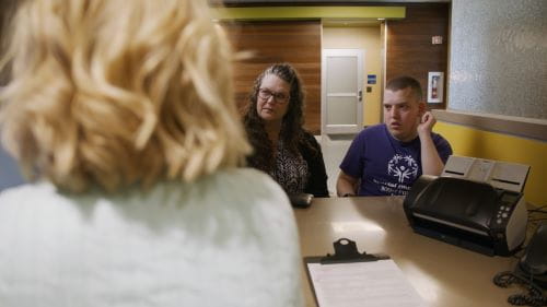 female caregiver and male patient with IDD checking in for a healthcare visit