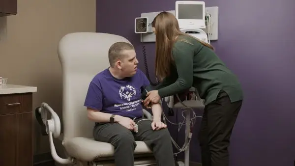 female nurse checking male patient with IDD blood pressure