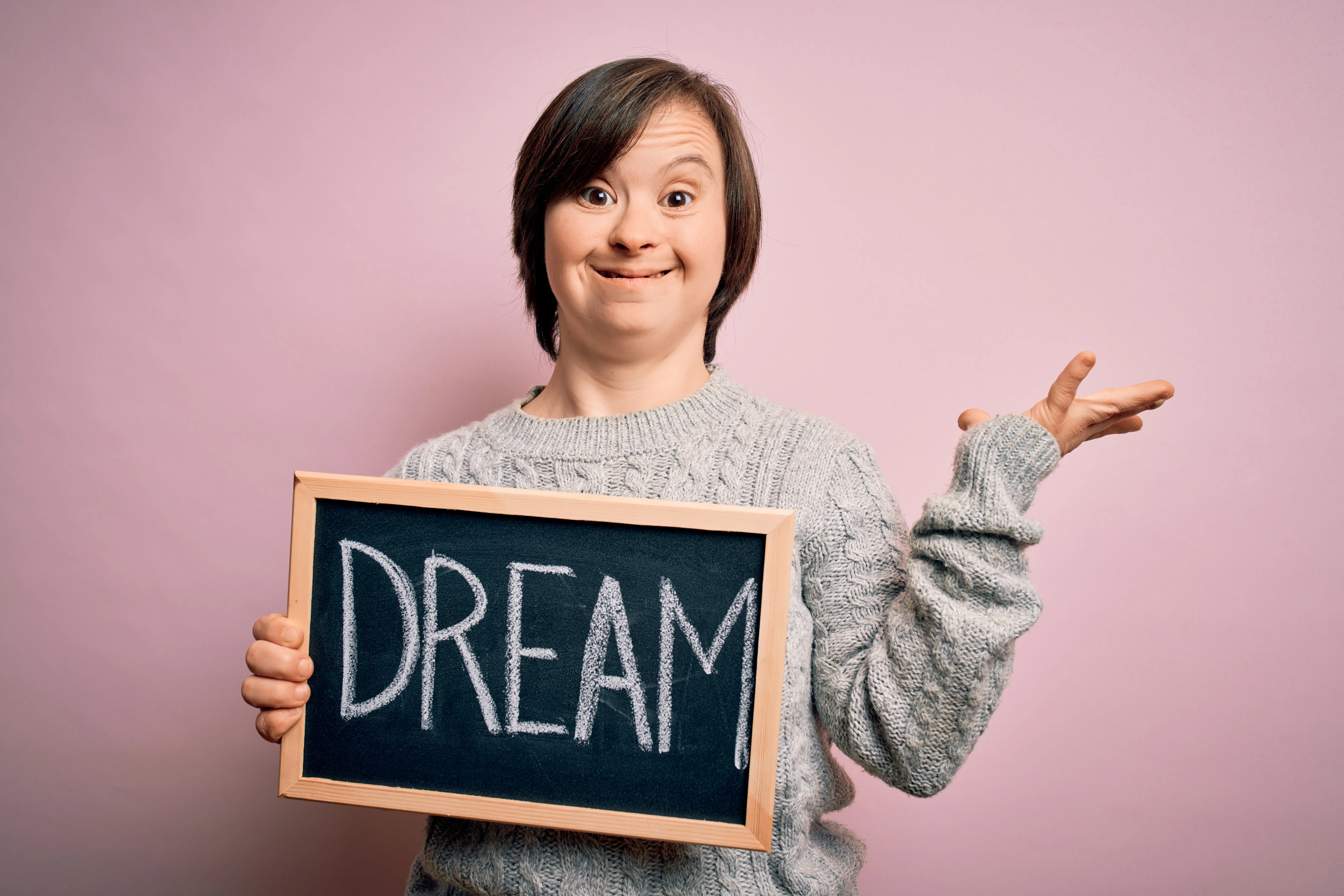 Woman with intellectual disability holding a sign that says dream