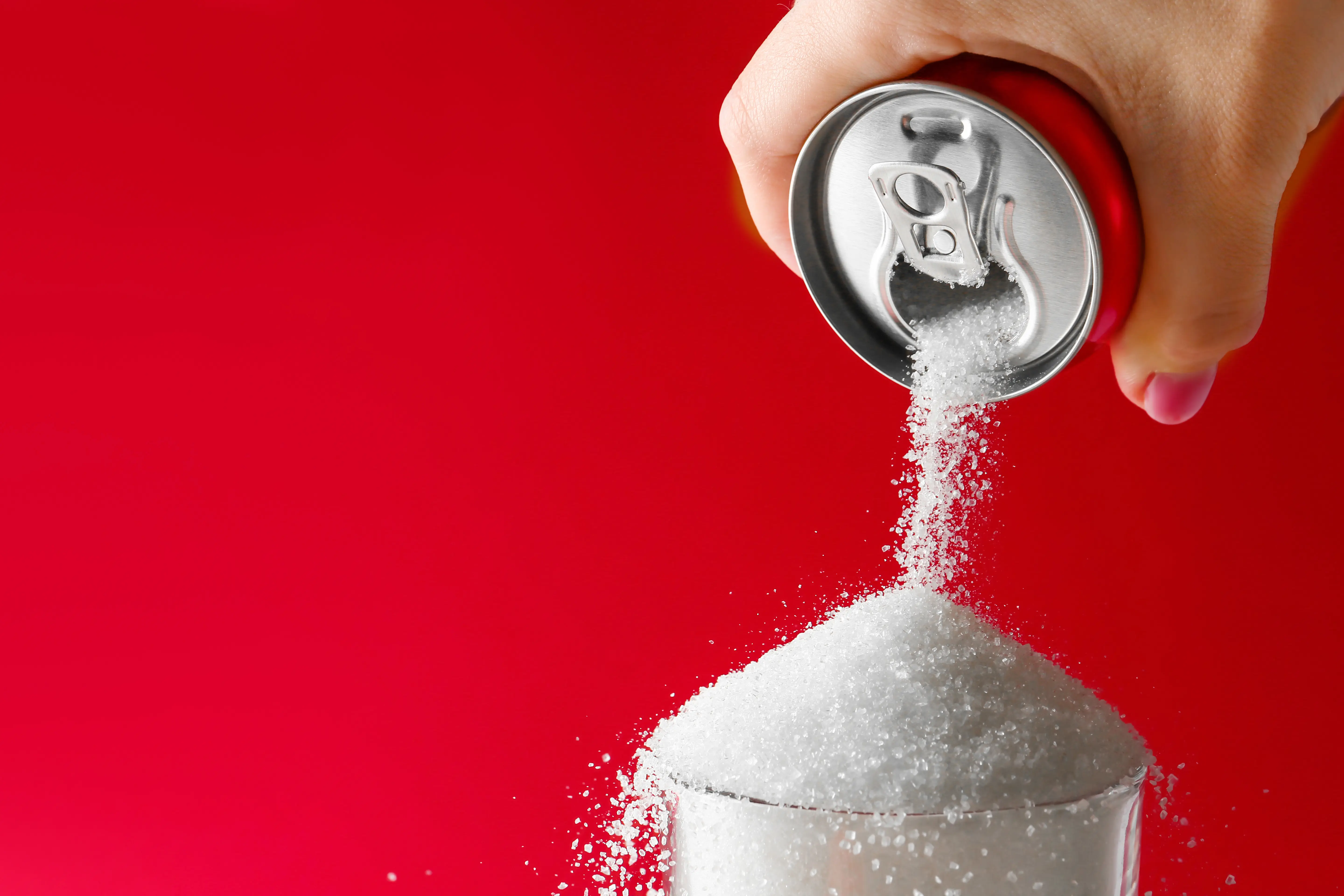 soda pouring sugar in glass
