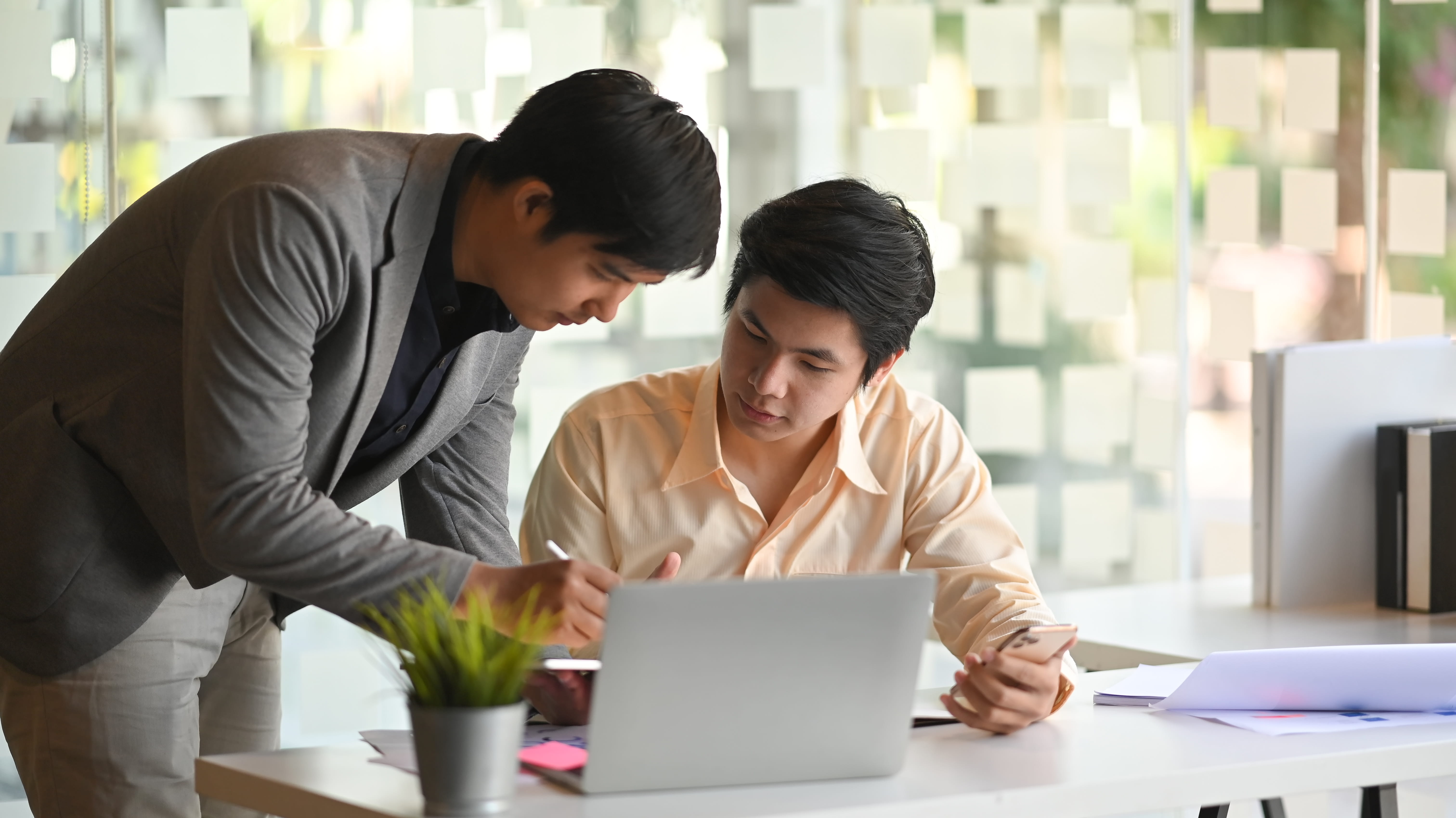 man showing another man something on the computer