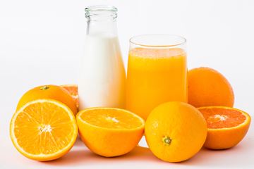 glass of milk and juice with oranges