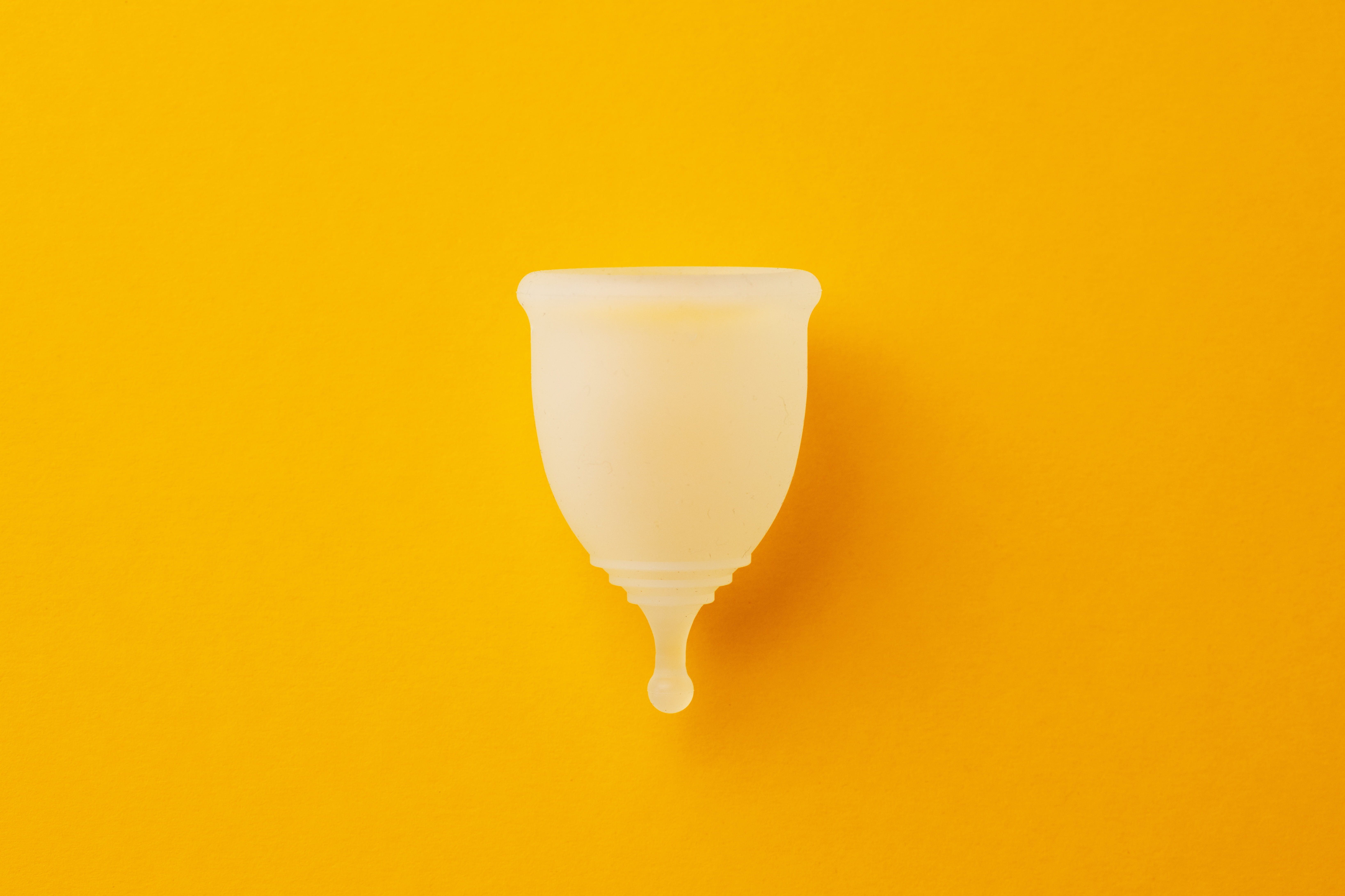 period cup in front of an orange background