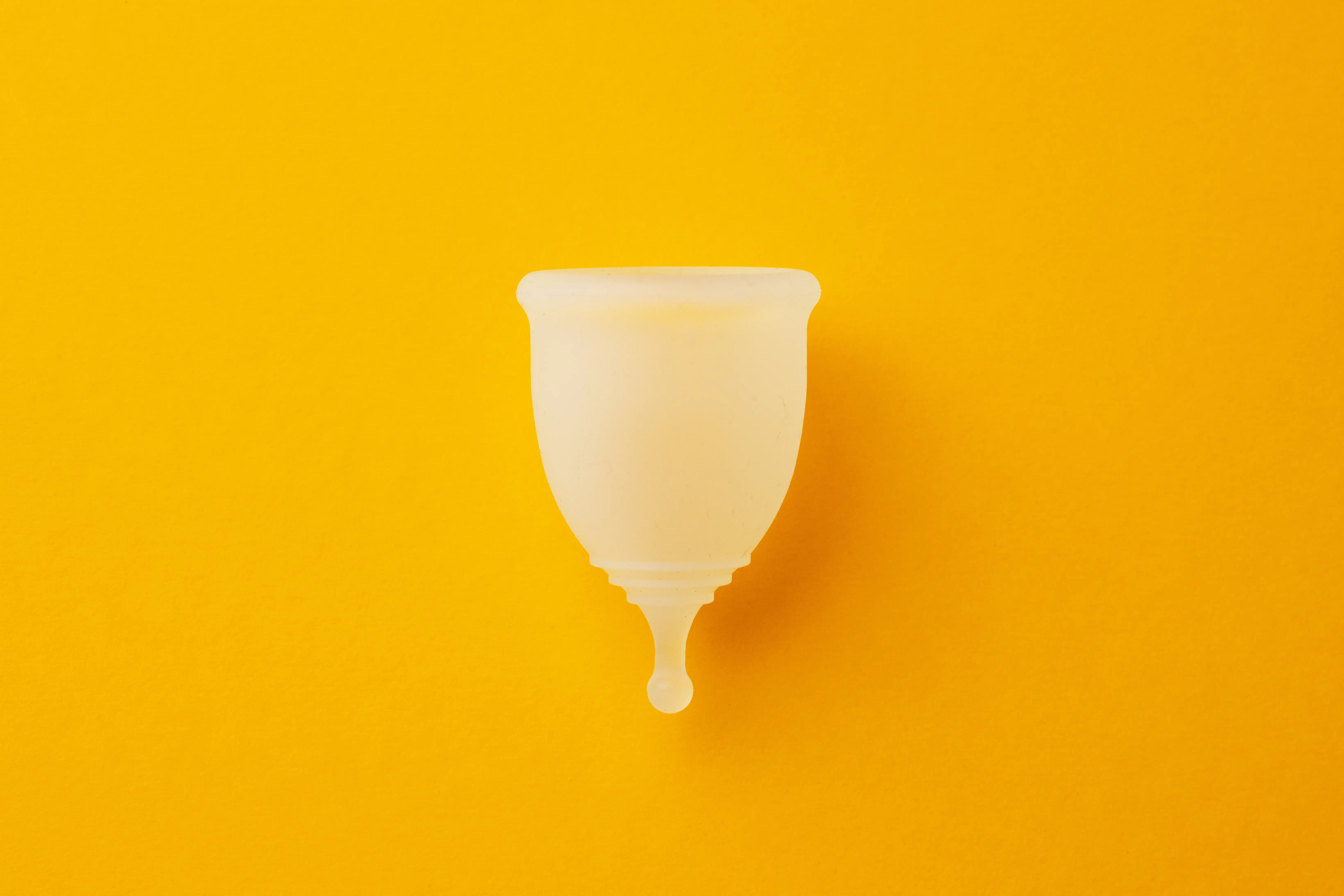 period cup in front of an orange background