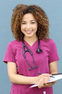 african american female nurse care coordinator in pink scrubs