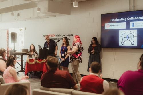 picture of people giving a presentation in front of screen that says celebrating collaboration